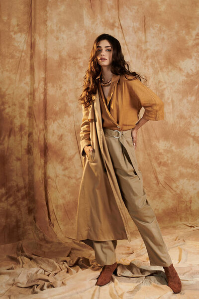 A young woman elegantly poses in a trendy autumn outfit, showcasing her flair for seasonal fashion in an inviting studio.