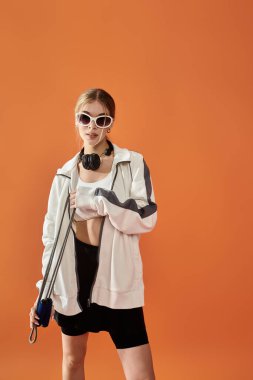 Yetenekli bir atlet spor kıyafetleri içinde güven içinde poz verirken duygularını ifade eder..