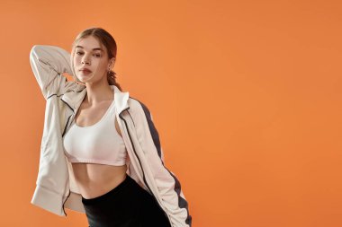 Güzel bir atlet, canlı bir ortamda enerjik bir şekilde poz verirken derin duygular ifade eder..