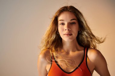 Tutkulu bir sporcu kadın, atletizm ve güzelliğini vurgularken derin duygularını ifade eder..