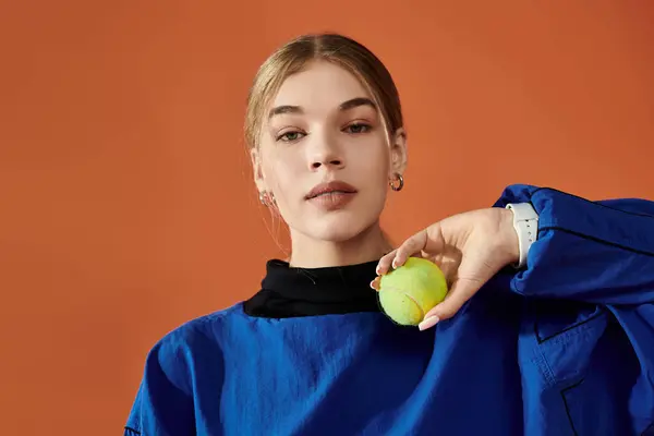 stock image A beautiful sportswoman exudes confidence and emotion while holding a tennis ball.