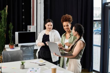 Three stylish businesswomen engage in a dynamic discussion while working together in an office. clipart