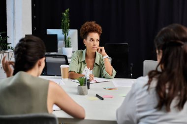 Three business professionals strategize in a modern office setting, focused on key decisions. clipart