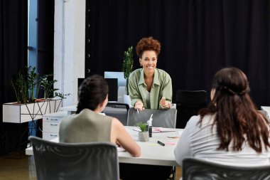 Kendine güvenen bir iş kadını şık bir ofis çalışma masasında ilgi çekici bir tartışmaya önderlik ediyor..