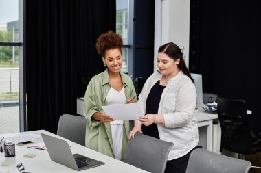 İki profesyonel kadın ofiste dokümanları incelerken anlamlı bir tartışmaya giriştiler..