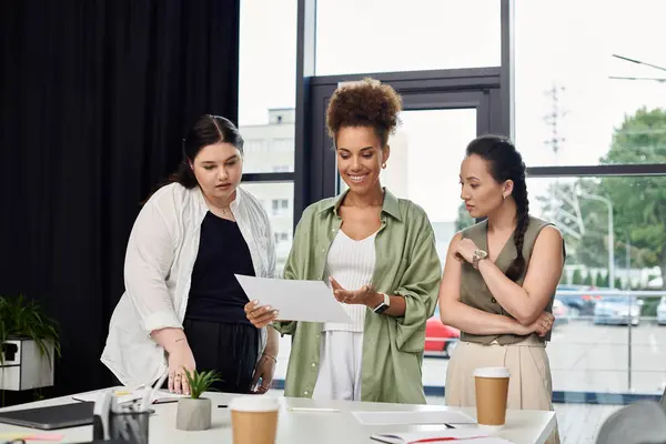 Stock image Three professionals collaborate over documents in a bright and stylish office setting.