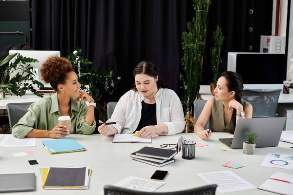 Три бизнесвумен участвуют в оживленной дискуссии, работая над проектом вместе.