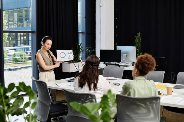 A confident woman presents ideas to her colleagues in an elegant office setting.