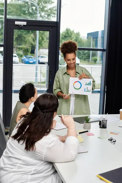 stock image A confident businesswoman leads a discussion with colleagues, showcasing her presentation skills.