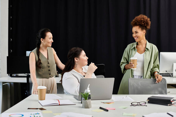 Три профессиональные женщины делятся идеями и смехом в стильной обстановке офиса за чашечкой кофе.