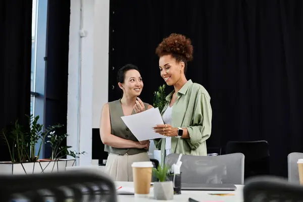 stock image In a contemporary office, two professional women engage in an insightful discussion, sharing ideas.