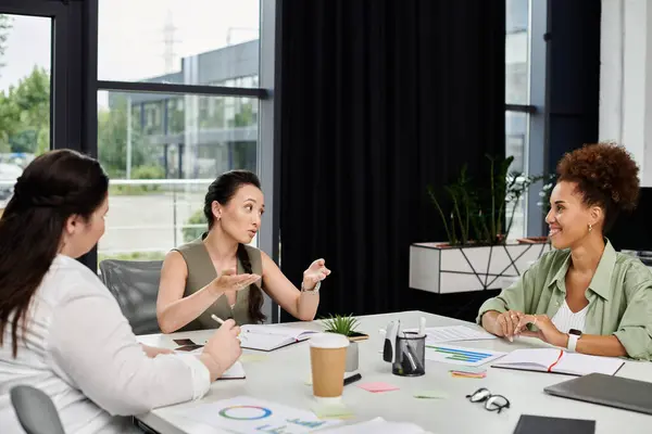 stock image Three professional women share ideas during an engaging discussion in their office environment.