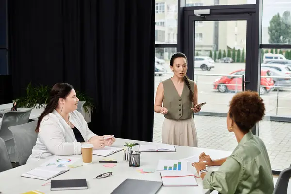 stock image Three professional women discuss strategies and insights in a contemporary office setting.