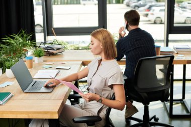 İş arkadaşları, enerji dolu dinamik bir çalışma alanını yansıtan görevleriyle meşguller..