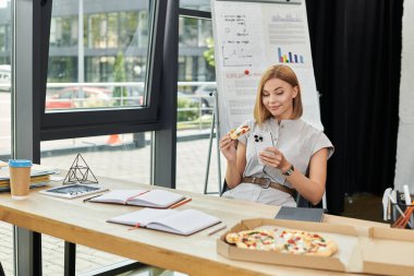 Genç bayan ofiste pizza yemekten hoşlanır..