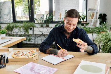 Yakışıklı adam ofiste pizza yemekten hoşlanıyor..