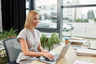 Canlı, yaratıcı bir ofis ortamında dizüstü bilgisayarda çalışan genç bir profesyonel..