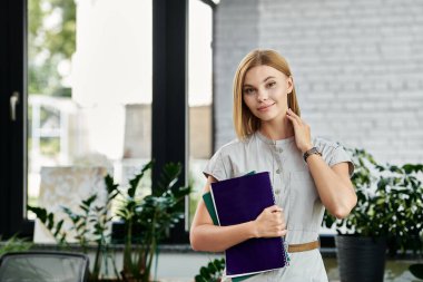 Young woman with blonde hair working in her office. clipart