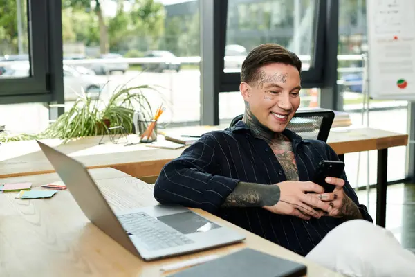 stock image A young professional shares a light hearted moment at desk, smiling at their phone.