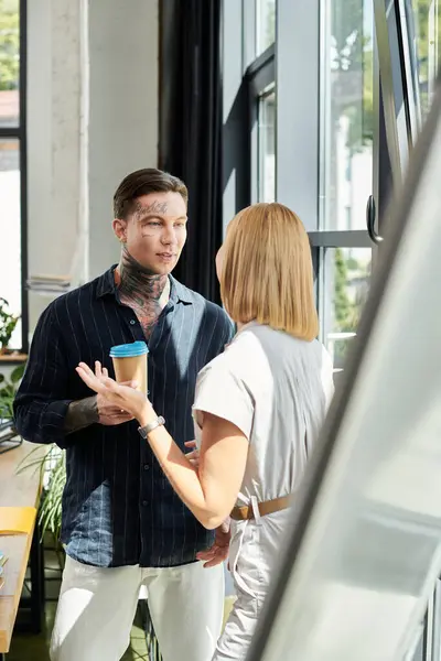 stock image Two young professionals share ideas and laughter while enjoying coffee by the window.