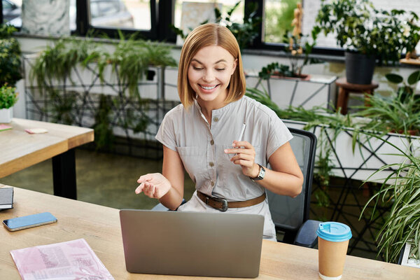 Веселый коллега вступает в оживленную дискуссию, работая за современным столом.