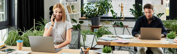 Два молодых профессионала сотрудничают в оживленном офисном помещении, заполненном зеленью.