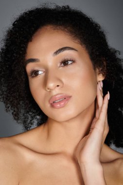 Zarifçe poz veren zarif bir kadın, doğal güzelliğini ön plana çıkarıyor..