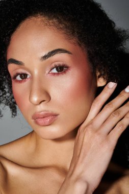 Şık bir kadın zarif bir şekilde poz verir, şık görünüşünü ve büyüleyici makyajını ön plana çıkarır..