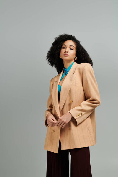 Одета в стильный пиджак и яркую блузку, она демонстрирует современную элегантность.