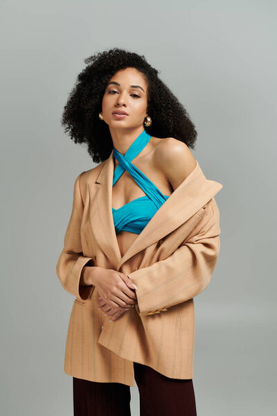 Женщина излучает элегантность и современный стиль в своем шикарном наряде.