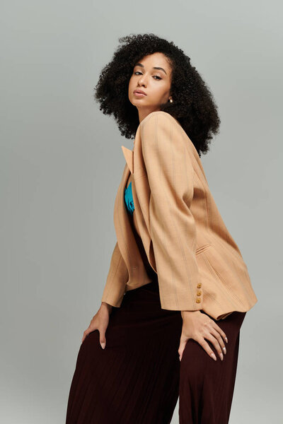 Красивая женщина демонстрирует свой шикарный наряд, излучая уверенность и элегантность в каждой позе.