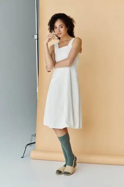 stock image A fashionable woman stands confidently, showcasing her style in a chic dress and playful socks.