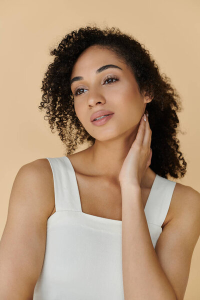 Стильно одетая женщина демонстрирует свою красоту и уравновешенность с вдумчивым выражением.