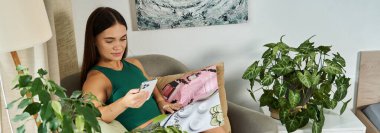 Kısa boylu genç bir kadın evinde vakit geçirmekten zevk alıyor. Sandalyesinde dinleniyor. Yeşilliğin ortasında telefonundan süzülüyor..