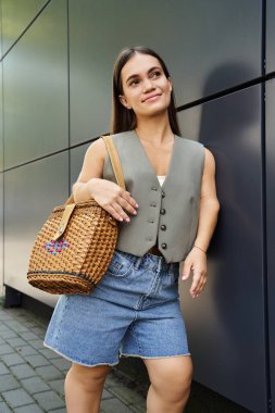Kendine güveni olan neşeli esmer bir kadın modern bir dış mekanı keşfediyor.