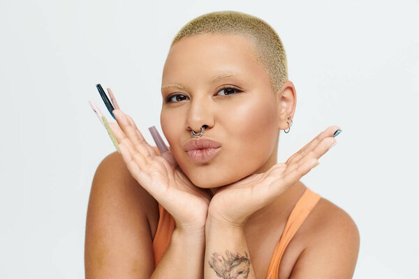 A bold young woman with a cheerful expression showcases vibrant style and unique nails.