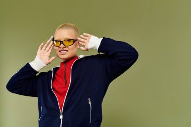 Bu enerjik genç kel kadın neşeli bir şekilde kendine güvenen bir gülümseme ile renkli bir şekilde poz veriyor..