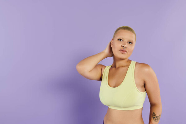 Уверенная в себе молодая женщина в яркой одежде выражает себя в увлекательной позе.