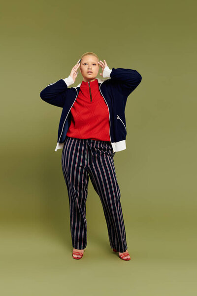 A young bald woman showcases her vibrant style with flair in innovative attire.