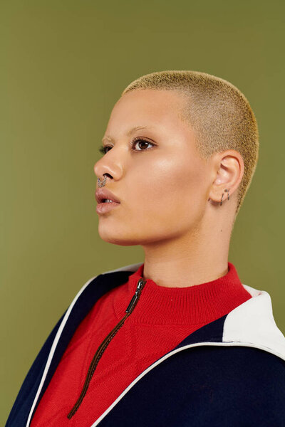 A young bald woman confidently displays her vibrant attire, embracing her unique style.