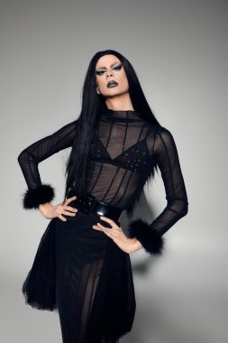 Büyüleyici bir travesti, siyah cüretkar bir kıyafetle, kendine güveni ve tarzıyla cinsiyet değişkenliğini kucaklıyor..