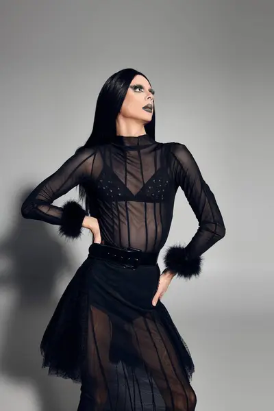 stock image A fashionable drag queen poses confidently in a chic black outfit, embodying elegance and boldness.