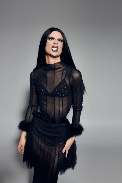 The stylish drag performer radiates confidence and creativity in a striking black outfit, embodying artistry.