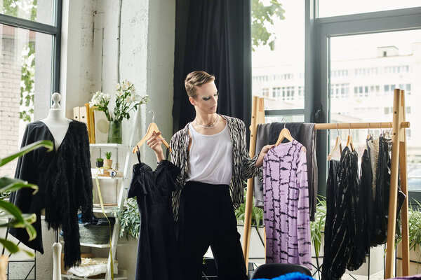 Dressed in stylish attire, a gender fluid fashion designer presents unique garments in their studio workspace.