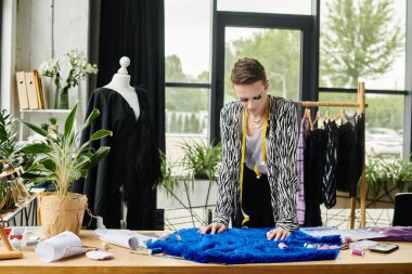 A fashionable transgender designer focuses on crafting vibrant garments in an inspiring studio environment. clipart