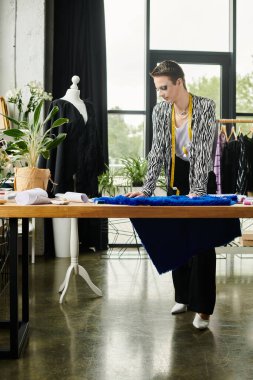 Modern bir stüdyoda, cinsiyet değiştiren bir moda tasarımcısı titizlikle renkli tasarımlar yapar..