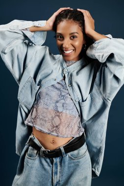Şık, genç bir kadın şık bir kot giysisiyle enerjik kişiliğini sergiliyor..