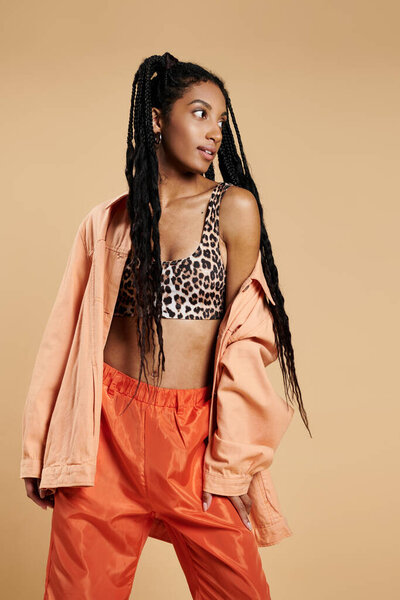 Модная молодая женщина демонстрирует свой модный наряд с уверенностью и чутьем.