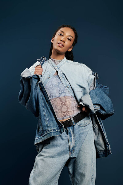 Молодая женщина демонстрирует свое чувство стиля в стильных джинсах, источая уверенность и творчество.