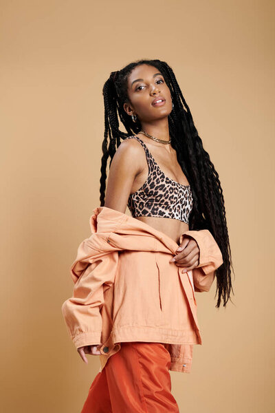 Уверенная в себе молодая женщина демонстрирует свой уникальный стиль в трикотажной, красочной одежде и игривой позе.